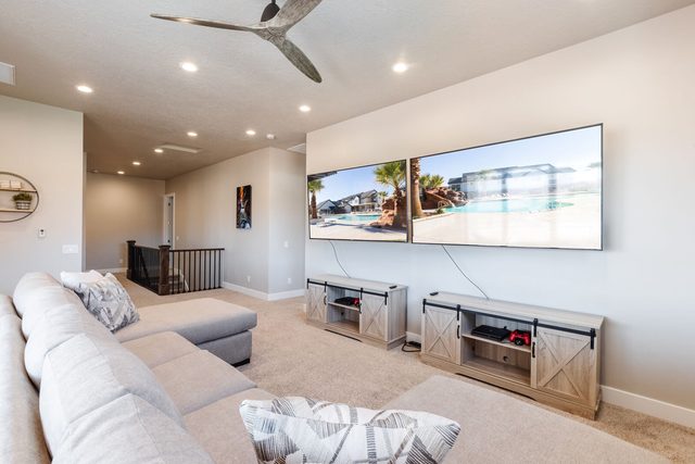 Upstairs loft with two wall-mounted TVs and sectional seating