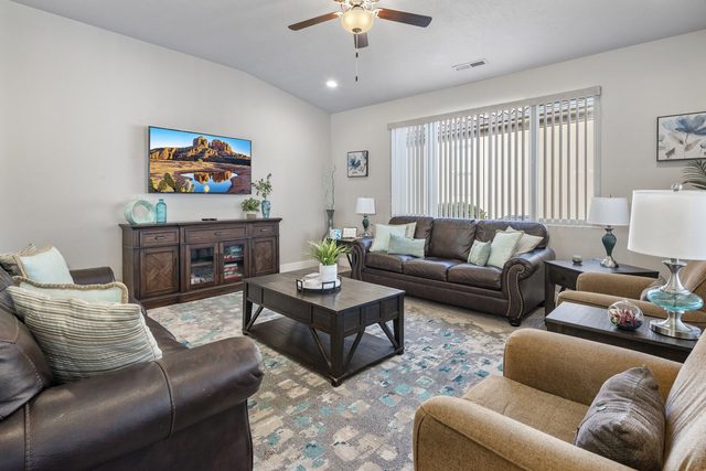 Living room seating facing the wall-mounted smart TV at Paradise Village 10