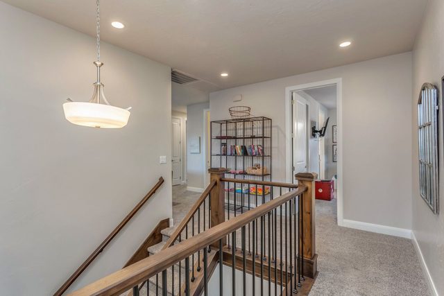 Upstairs landing with staircase railing and hallway