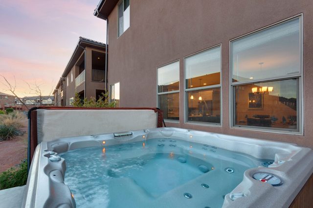 Private hot tub beside the house under a pink sky