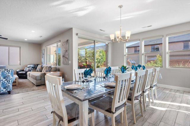 Long dining table beside large windows and the living room