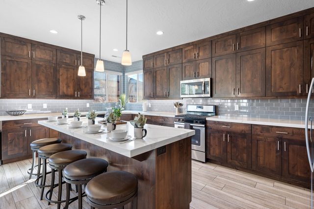 Kitchen island with bar stools and dark wood cabinets