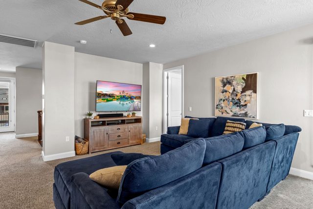 Upstairs loft lounge with blue sectional and smart TV