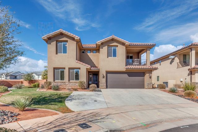 Two-story stucco front exterior with garage and driveway at Paradise Village 107