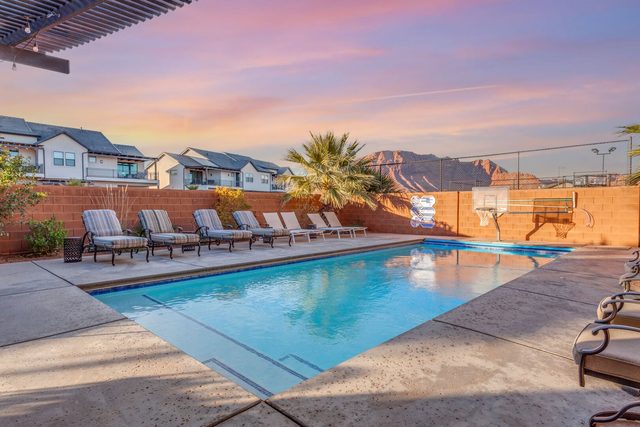 Private pool with row of lounge chairs at sunset