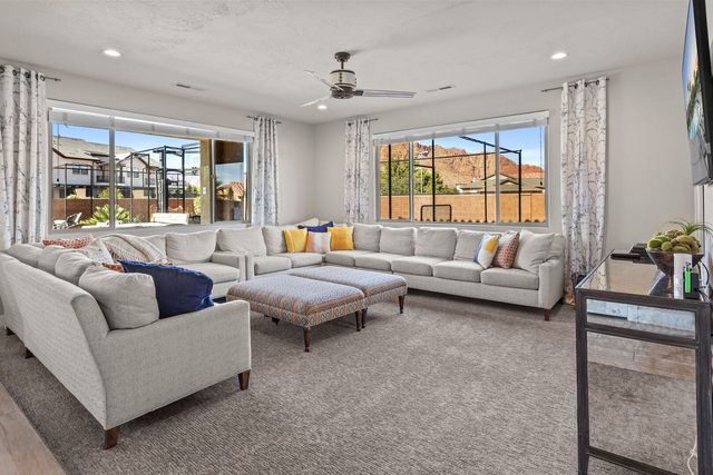 Living room with large sectional and windows toward the backyard