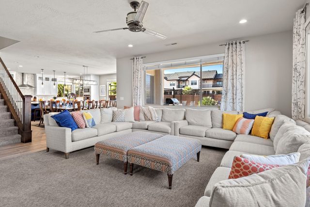 Great room with sectional sofa, ottomans and staircase