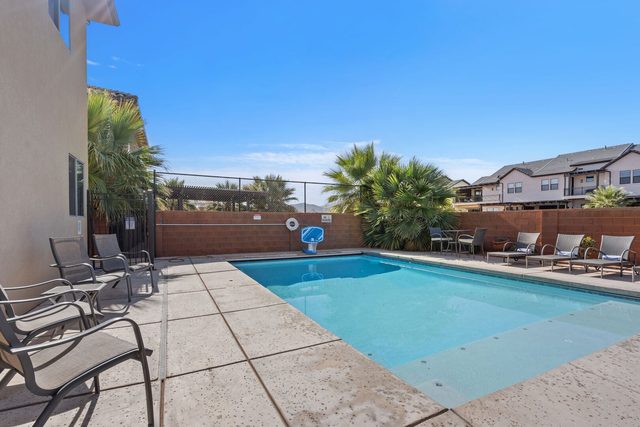 Private pool with lounge chairs along the backyard wall