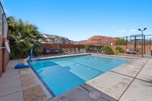 Private pool with basketball hoop toy and red rock views