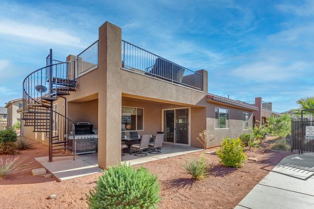 Back exterior with spiral staircase to the rooftop deck and patio