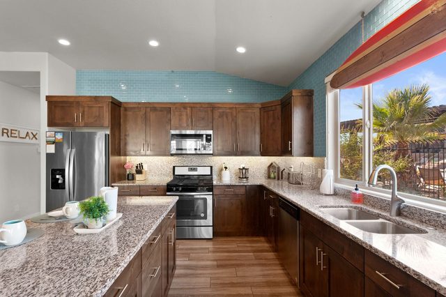 Kitchen with gas range, granite counters and window over the sink