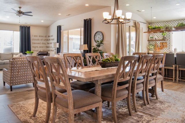 Farmhouse dining table with chandelier and bar seating beyond