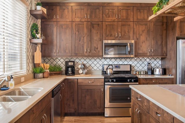Kitchen with wood cabinets, gas range and quartz counters