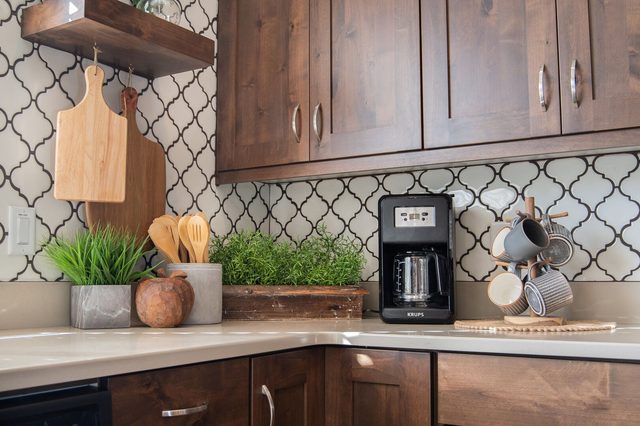 Kitchen counter with coffee maker and patterned tile backsplash