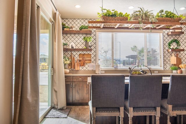 Kitchen bar with tall stools and plant shelves by the patio door