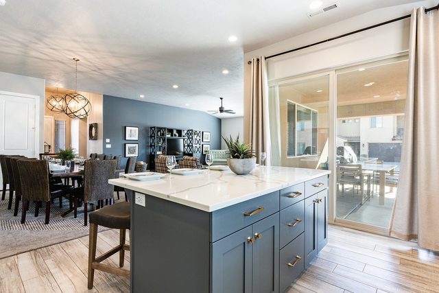 Kitchen island with quartz counter beside sliding doors to the patio