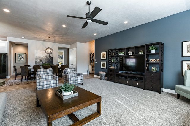 Living room with plaid armchairs, coffee table and media wall