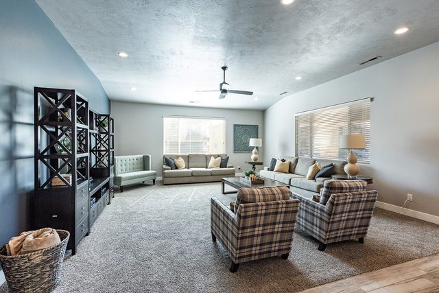 Spacious carpeted family room with sectional seating and TV cabinet