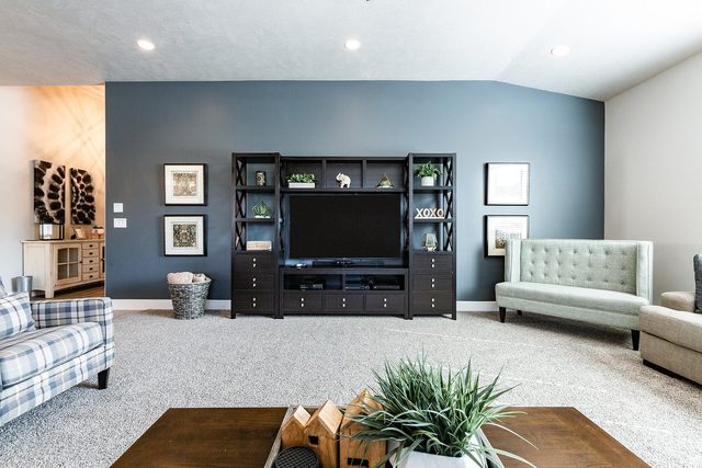 Family room TV entertainment center with accent wall and settee