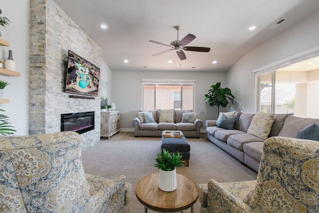 Living room with stone fireplace, wall TV and sectional seating