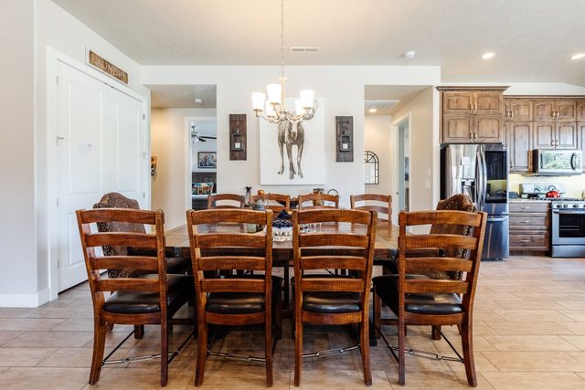 Dining table with ladder-back chairs in front of the kitchen
