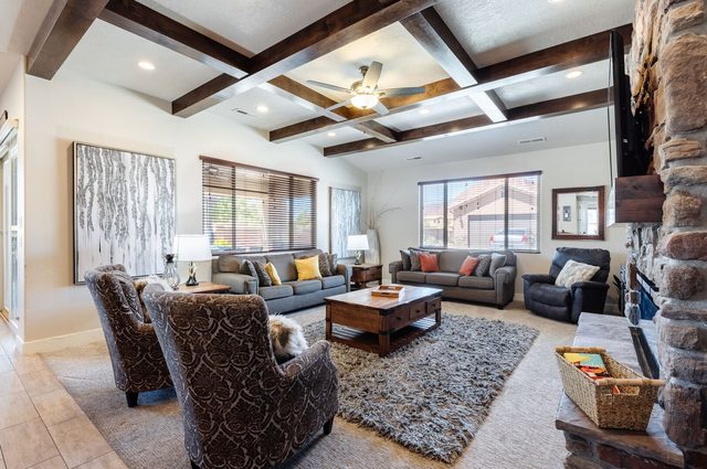 Living room with coffered beam ceiling, sofas and stone fireplace