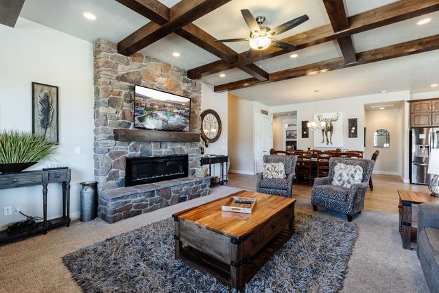 Living room with stone fireplace, TV and view to dining area