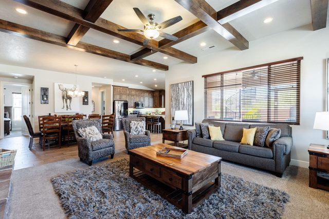 Open living room with beamed ceiling flowing into the dining room