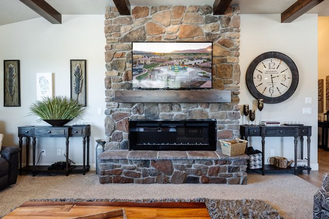 Stacked stone fireplace with electric insert and wall-mounted TV