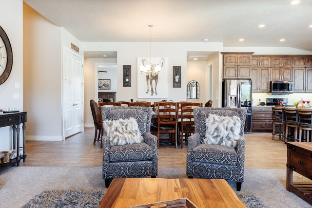 Living room armchairs looking toward the dining table and kitchen