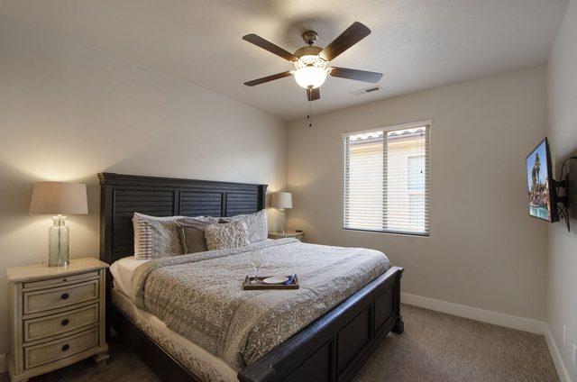King bedroom with dark wood bed and wall-mounted TV