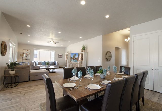 Dining table set for a group with the living room beyond