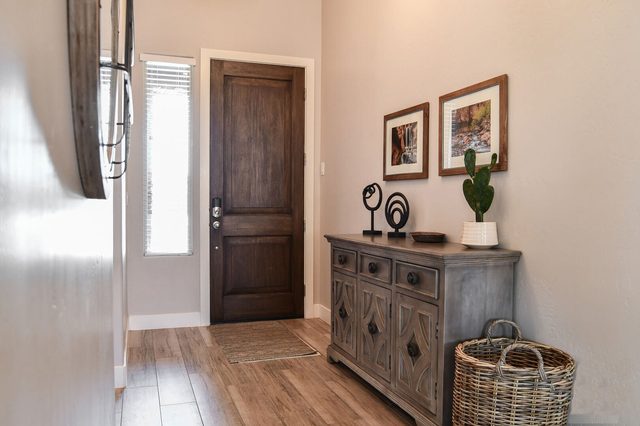 Front entry with wood door, console table and framed art
