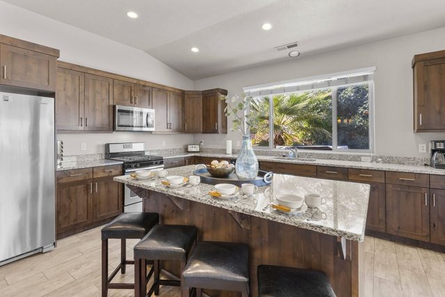 Kitchen island with four bar stools and stainless appliances