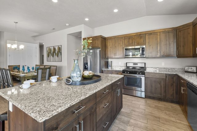Granite kitchen island and wood cabinets beside the dining area