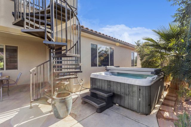 Private hot tub on the side patio below the balcony stairs