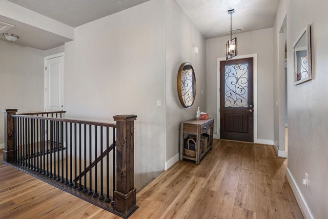 Entry hall with wood floors and staircase railing