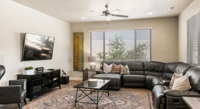 Unit 18 living room with leather sectional and wall TV