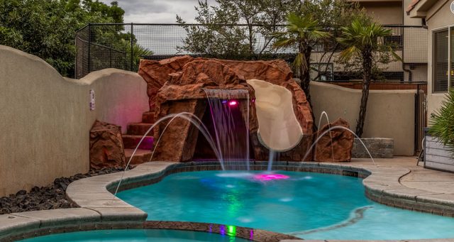 Lit rock grotto waterfall and slide over the Unit 18 pool