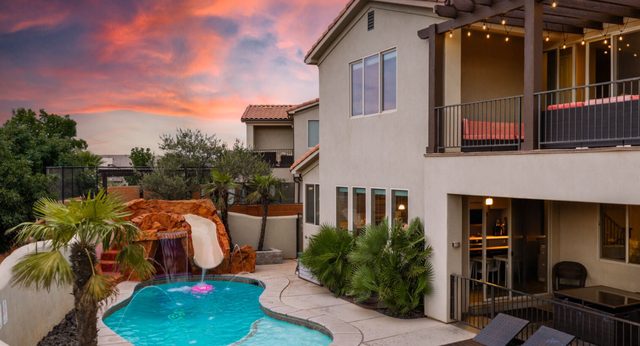 Unit 18 backyard pool, grotto and covered patio at sunset