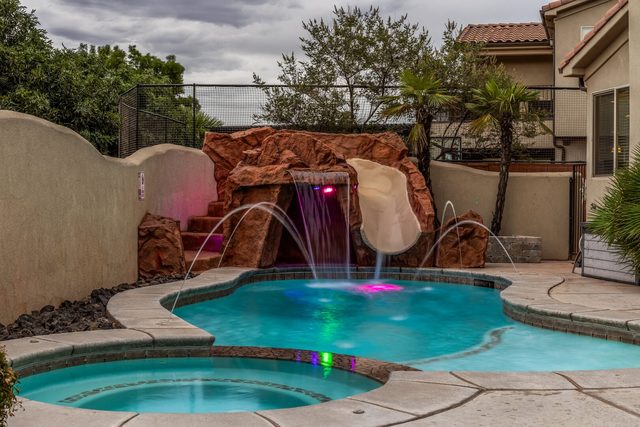 Private pool with rock waterfall, slide and lit fountains