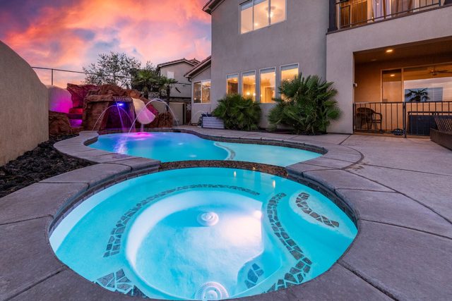 Private hot tub and pool with glowing rock waterfall