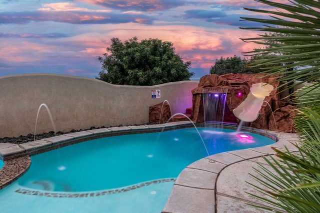 Private pool fountains and rock waterslide at sunset