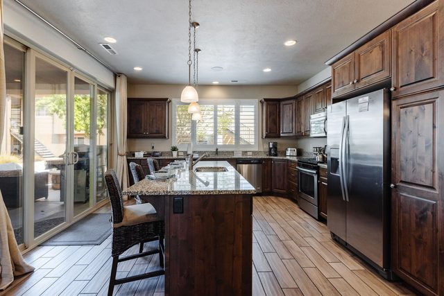 Kitchen with granite island, bar seating and patio doors at Paradise Village 28