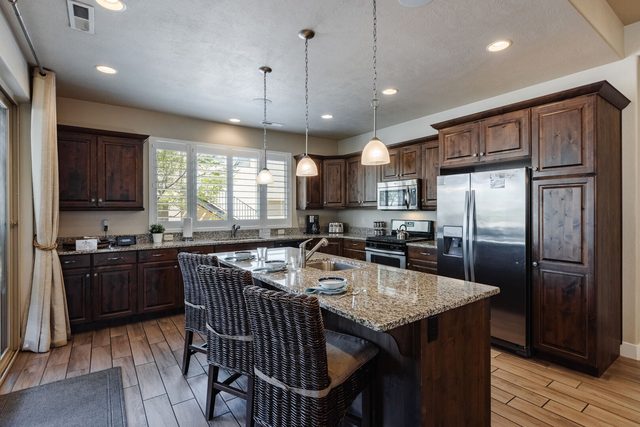Kitchen island with bar stools and stainless refrigerator at Paradise Village 28
