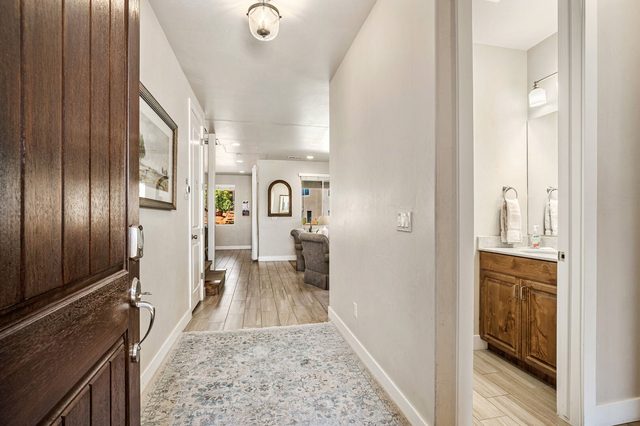 Front entry hallway with wood door and half bath