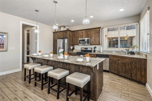 Kitchen island with four bar stools and pendant lights at Paradise Village 32