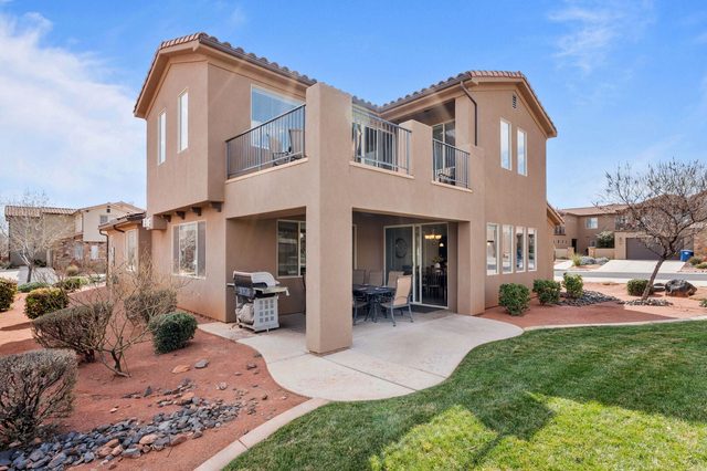 Back of Paradise Village 36 with patio, balconies and green lawn