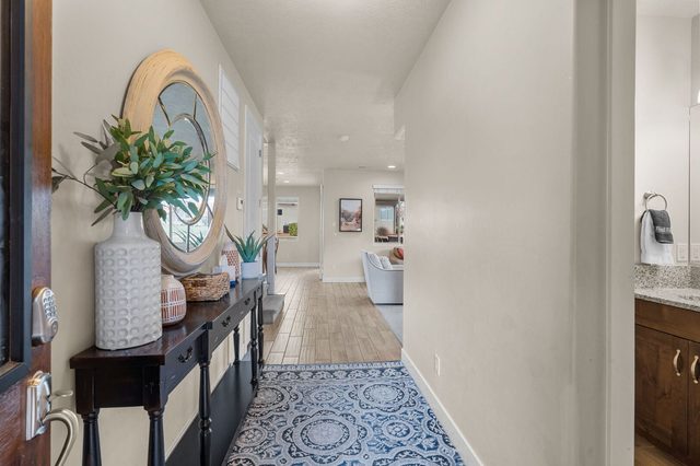Front entry hallway with console table and round mirror at Paradise Village 36