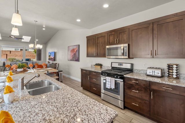 Kitchen counters with gas range, microwave and dark cabinets